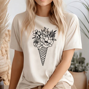 a woman wearing a t - shirt with an ice cream cone with flowers on it