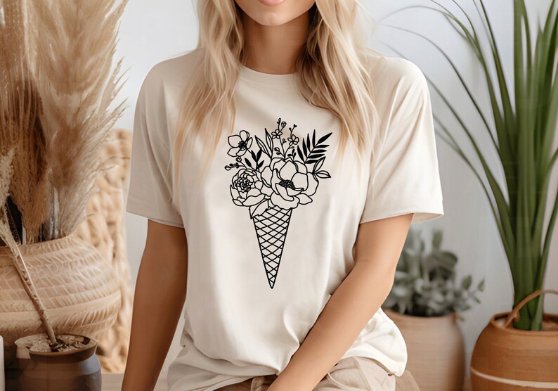 a woman wearing a t - shirt with an ice cream cone with flowers on it