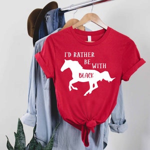 May include: Red t-shirt with a white silhouette of a horse and the text "I'd rather be with black".