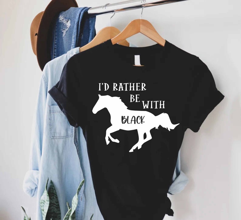 May include: Black t-shirt with white text that reads "I'd rather be with black" and a white silhouette of a horse.