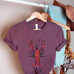 a purple shirt with a lobster on it