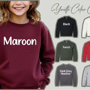 a young girl wearing a maroon sweatshirt with the name maroon on it