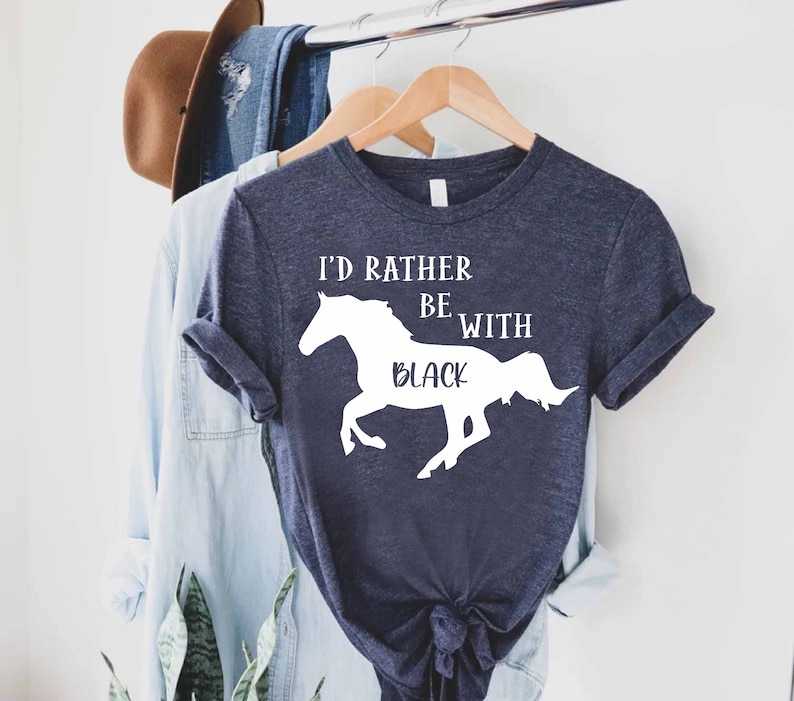 May include: A navy blue t-shirt with a white silhouette of a horse and the text "I'd rather be with black".