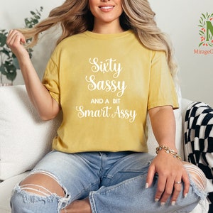 a woman sitting on a couch wearing a yellow shirt