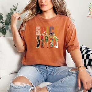 a woman is sitting on a couch wearing a t - shirt