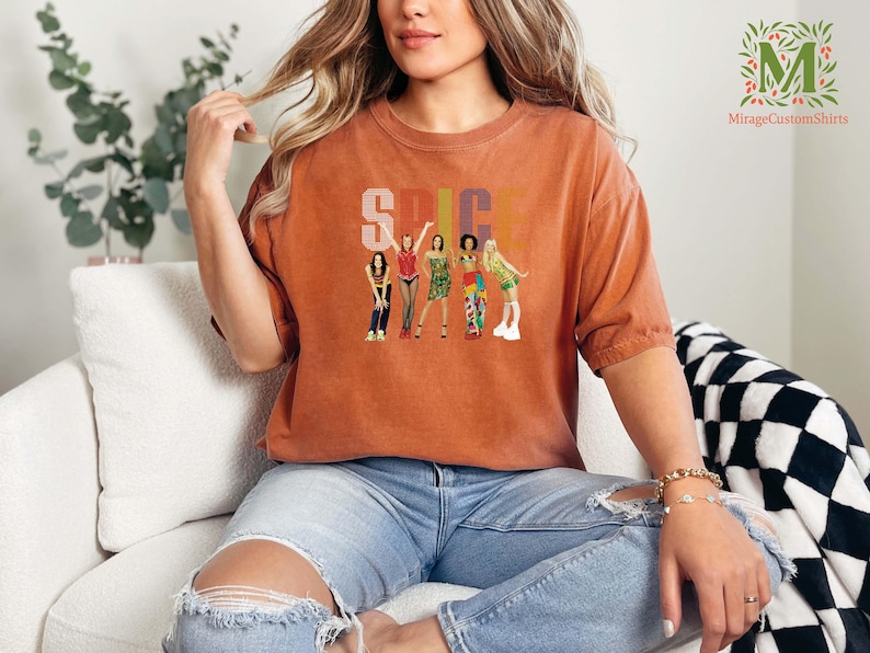 a woman is sitting on a couch wearing a t - shirt