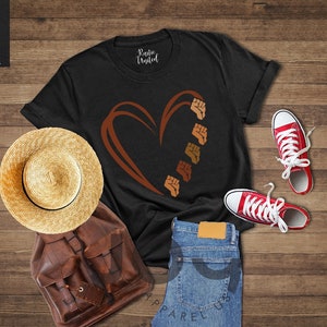 a t - shirt with a heart on it next to a pair of jeans and