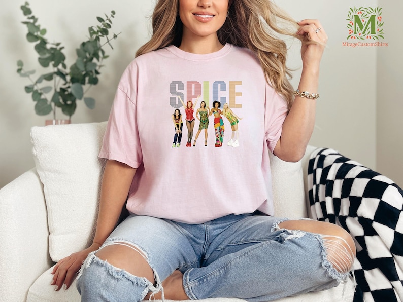 a woman sitting on a couch wearing a pink t - shirt