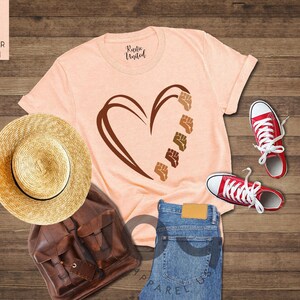 a t - shirt with a heart on it next to a pair of jeans and