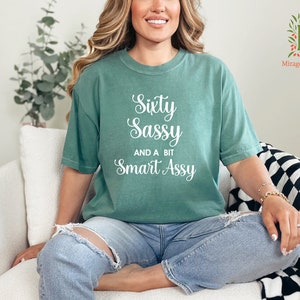 a woman sitting on a couch wearing a green shirt