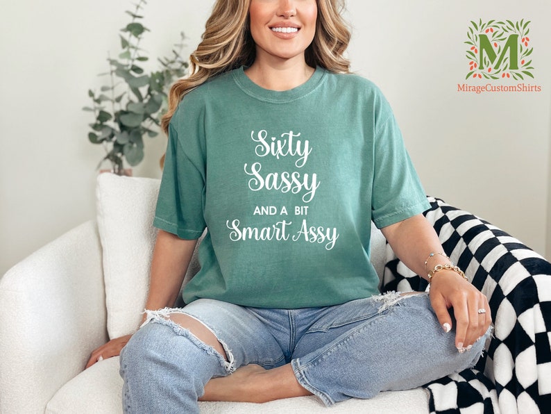a woman sitting on a couch wearing a green shirt