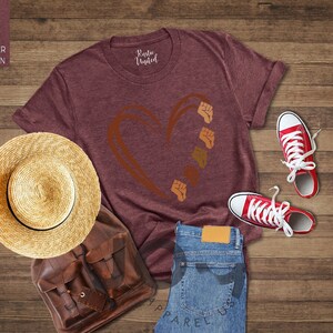 a t - shirt, hat, and pair of jeans on a wooden floor