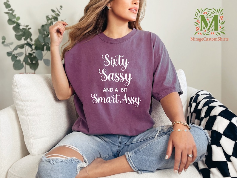 a woman sitting on a couch wearing a shirt that says sexy sasy and a