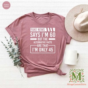 a t - shirt that says fake news says i'm 60 but the alternative