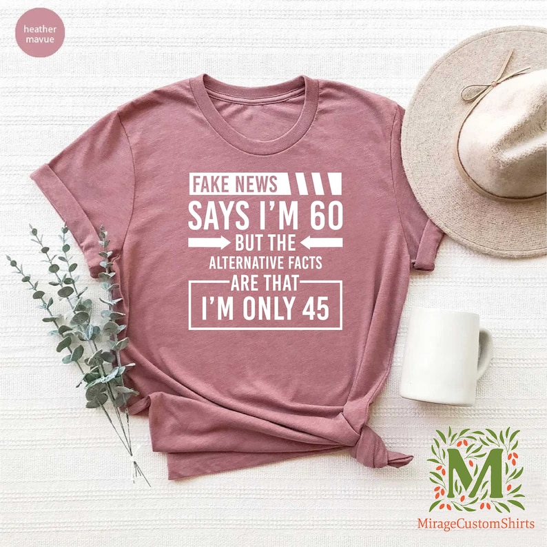 a t - shirt that says fake news says i'm 60 but the alternative