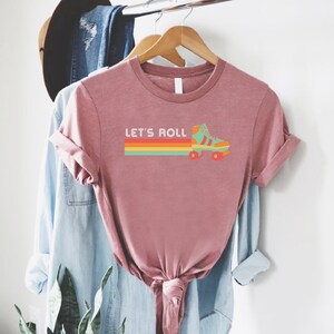 a t - shirt hanging on a rack with a plant