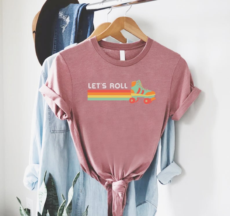 a t - shirt hanging on a rack with a plant