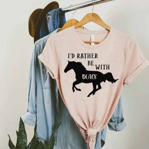 May include: A pink t-shirt with the text "I'd rather be with black" and a silhouette of a black horse running.