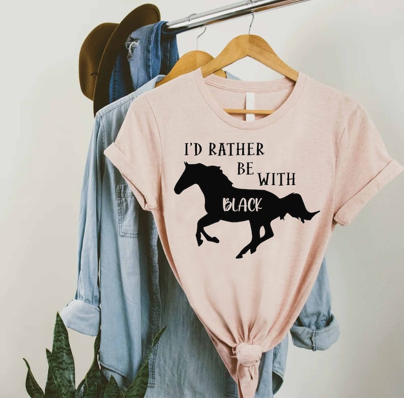 May include: A pink t-shirt with the text "I'd rather be with black" and a silhouette of a black horse running.