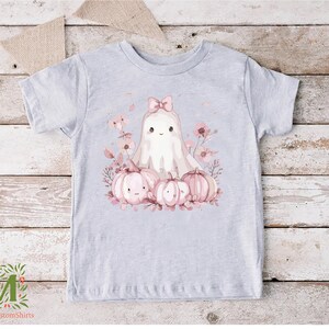 a t - shirt with a picture of a ghost surrounded by pumpkins