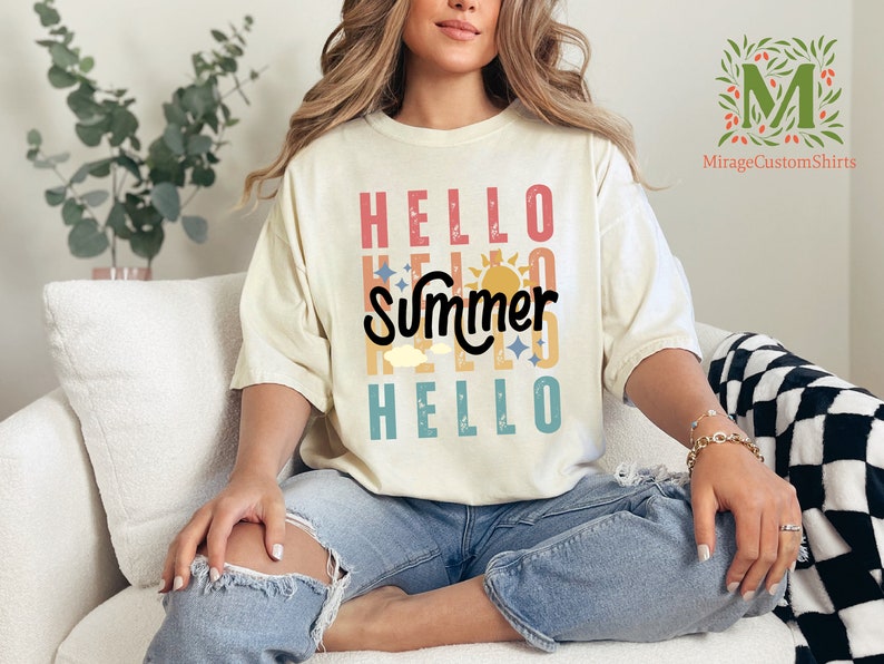 a woman sitting on a white couch wearing a t - shirt that says hello summer