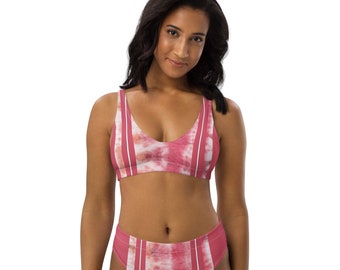 Op de afbeelding: Een roze en witte tie-dye bikini top en broek met dunne rode strepen. De bikini top heeft een v-hals en de bikini broek is hoog getailleerd.