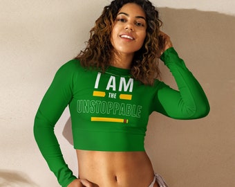 May include: A green long-sleeved crop top with the text "I AM THE UNSTOPPABLE" in white with yellow accents.