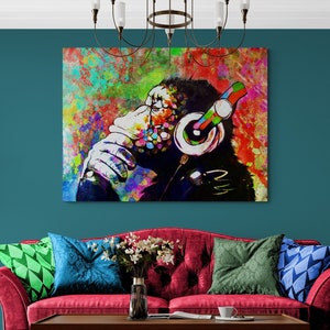 May include: A colourful abstract painting of a monkey wearing headphones. The monkey is sitting with its chin on its hand and looking to the side. The background is a mix of bright colours, including red, blue, green, and yellow.