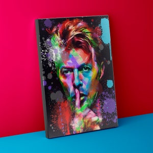 May include: A colorful abstract portrait of a man with his finger to his lips, as if to say "shh". The background is black with colorful paint splatters.