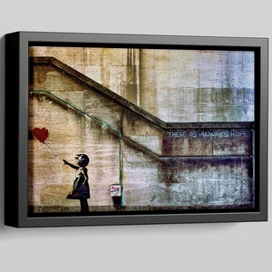 May include: A black and white stencil of a girl letting go of a red heart-shaped balloon. The stencil is on a weathered brick wall with the words "There is always hope" written in white paint.