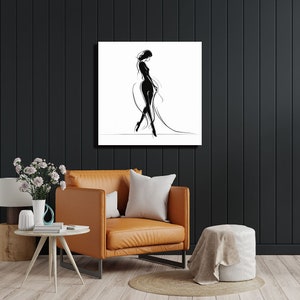 Pode incluir: Impress&atilde;o em preto e branco de arte de linha de uma mulher com um vestido fluido. A impress&atilde;o est&aacute; sobre um fundo branco e &eacute; emoldurada em uma moldura preta simples.