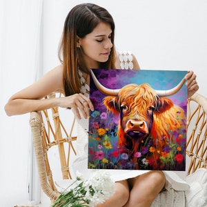 Pu&ograve; includere: Un dipinto di una mucca delle Highlands con pelo lungo e irsuto, in piedi in un campo di fiori selvatici colorati. La mucca ha un viso marrone e bianco e grandi occhi scuri. Lo sfondo &egrave; un cielo vibrante viola e blu.