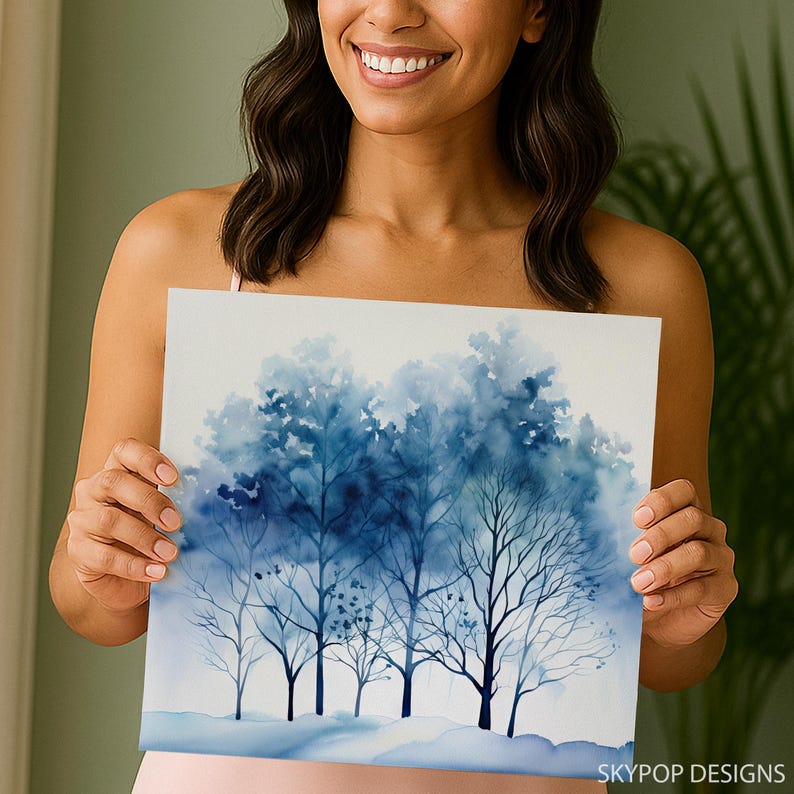 May include: A watercolor painting of a winter forest scene. The artwork features trees in varying shades of blue, with a snowy ground. The painting has a soft, ethereal quality, with the text "SKYPOP DESIGNS" in the bottom right corner.