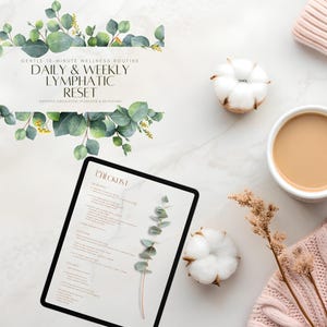 Op de afbeelding: Een flatlay met een witte mok gevuld met koffie, een roze gebreide trui, een digitale tablet met een checklist en twee katoenen bollen. De tablet toont de tekst: "GENTLE 10-MINUTE WELLNESS ROUTINE DAILY & WEEKLY LYMPHATIC RESET".