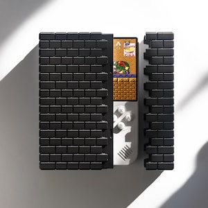 May include: A black brick-patterned case with a white handheld video game console inside. The console has a color screen displaying a video game with the text "Bunny  Bonus  Pizza".