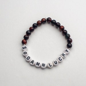 Pulseira So Damn Lucky - Feita com pedras preciosas de olho de tigre de 6 mm - Ótima ideia de presente para o fã de música em sua vida!