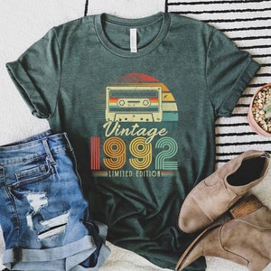 May include: A green t-shirt with a vintage cassette tape and the text "Vintage 1992 Limited Edition".
