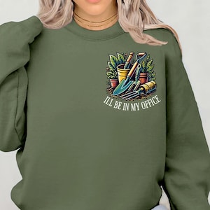 Peut inclure: Un sweat-shirt vert avec un motif d'outils de jardinage et le texte "I'll be in my office".