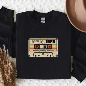 May include: Black sweatshirt featuring a vintage cassette tape graphic that reads "Best of 1976" and "40 Years of Being Awesome".