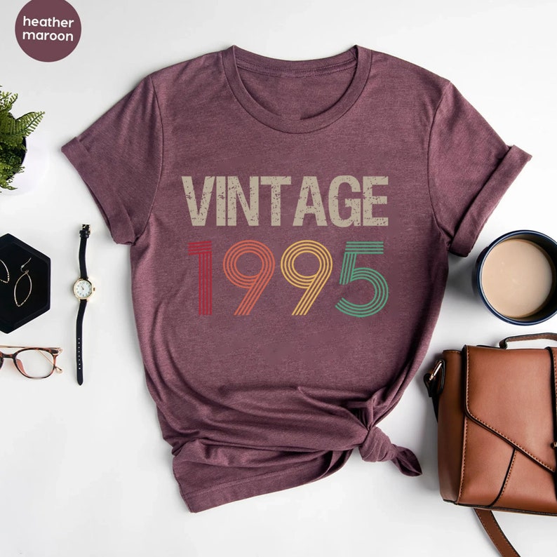 May include: Heather maroon t-shirt with a vintage 1995 graphic in rainbow colors. The graphic has a distressed look.