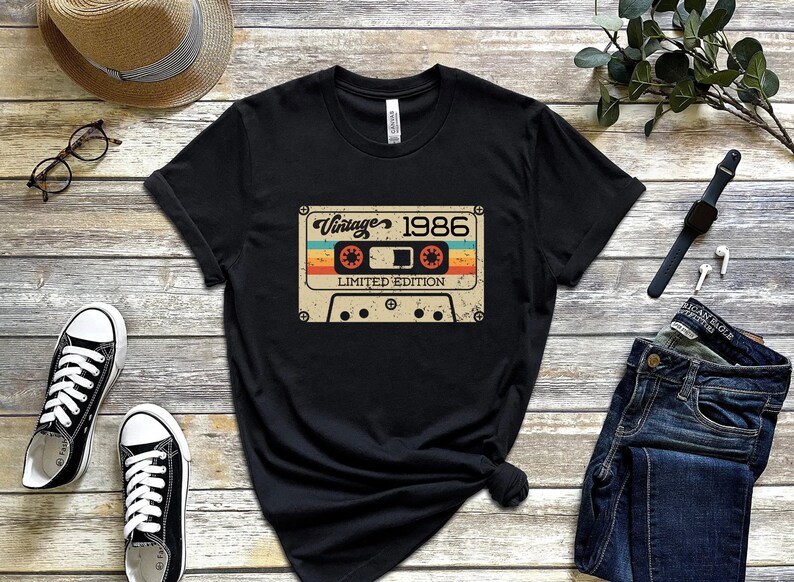May include: Black t-shirt featuring a vintage cassette tape graphic. The tape has the text "Vintage 1986 Limited Edition" printed on it.