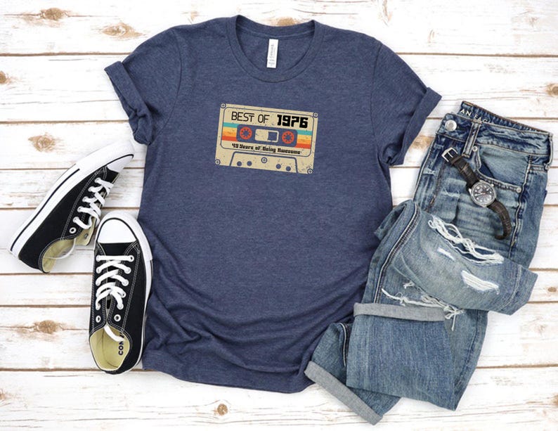 May include: A navy blue t-shirt featuring a vintage cassette tape graphic that reads "Best of 1976 40 Years of Being Awesome".