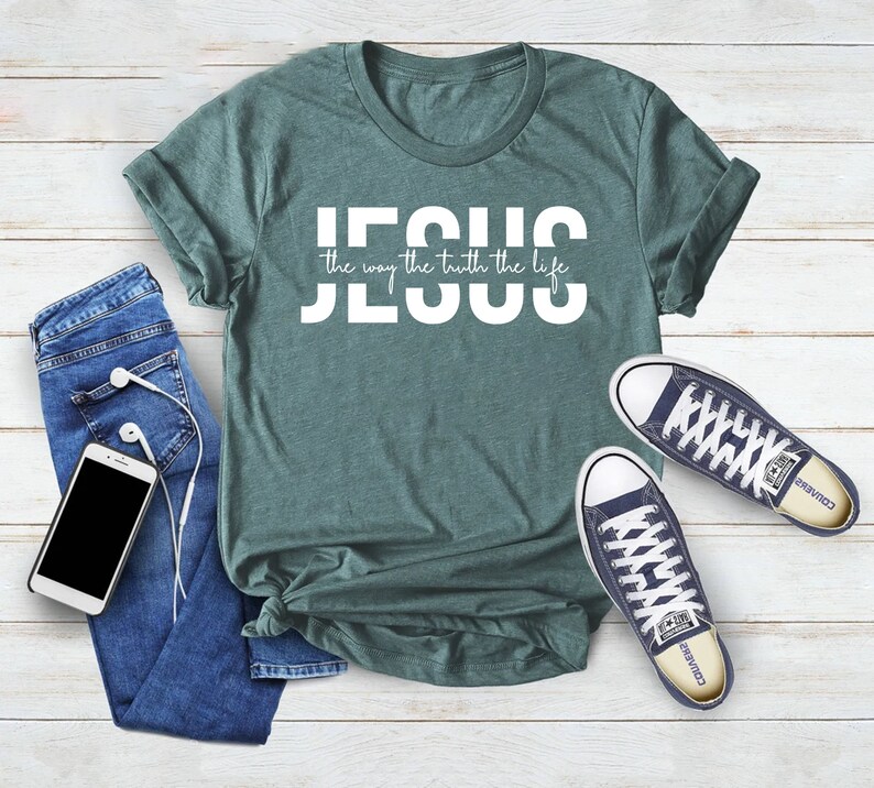 Pu&ograve; includere: Una maglietta verde acqua con la scritta "JESUS the way the truth the life" in lettere bianche.