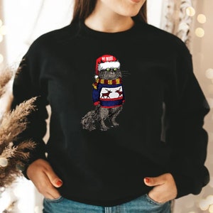 K&ouml;nnte beinhalten: Ein schwarzer Pullover mit einem Aufdruck eines Katers, der einen Weihnachtsmann-Hut und einen Weihnachtspullover mit Rentieren tr&auml;gt. Der Text "My Mood" steht auf dem Hut.