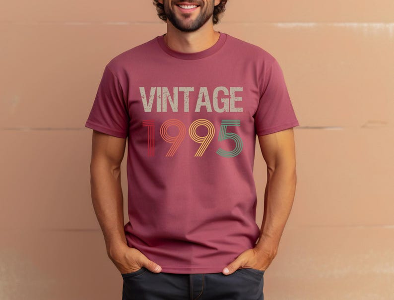 May include: A maroon t-shirt with the text "Vintage 1995" in a retro font with multi-colored outlines.