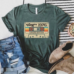 May include: A green t-shirt with a vintage cassette tape graphic. The tape has the text "Vintage 1976 Limited Edition".
