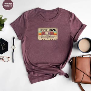 May include: Heather maroon t-shirt featuring a vintage cassette tape graphic that reads "Best of 1976 43 Years of Being Awesome".