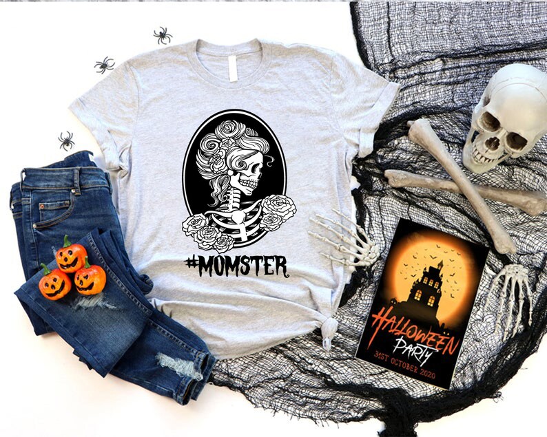 May include: A gray t-shirt with a black and white illustration of a skeleton with flowers in its hair. The text "#MOMSTER" is printed below the illustration.