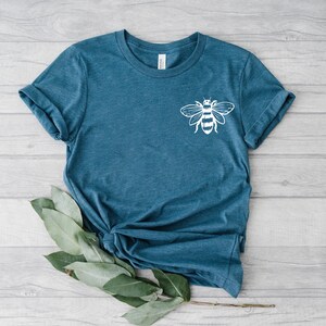 May include: A teal blue t-shirt with a white bee graphic on the front.