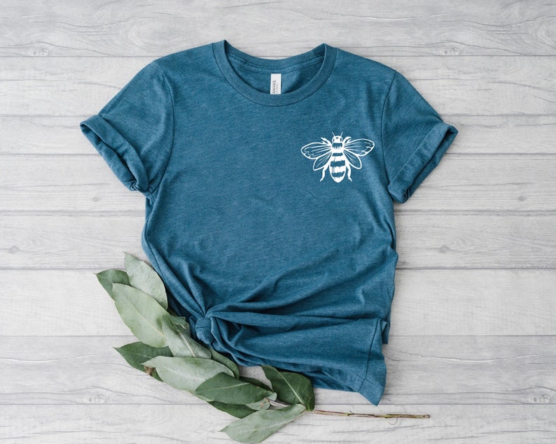 May include: A teal blue t-shirt with a white bee graphic on the front.